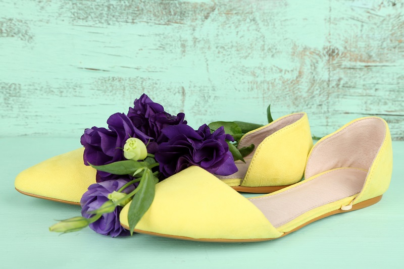 D'Orsay Flats: Sleek and Chic Beautiful woman shoes with flowers on wooden background