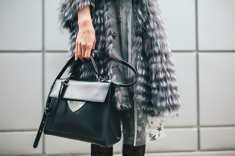 Satchel Bags: Comfort yet Stylish close up accessories details of stylish woman walking in city in warm fur coat, winter season, cold weather, holding leather bag, street fashion trend
