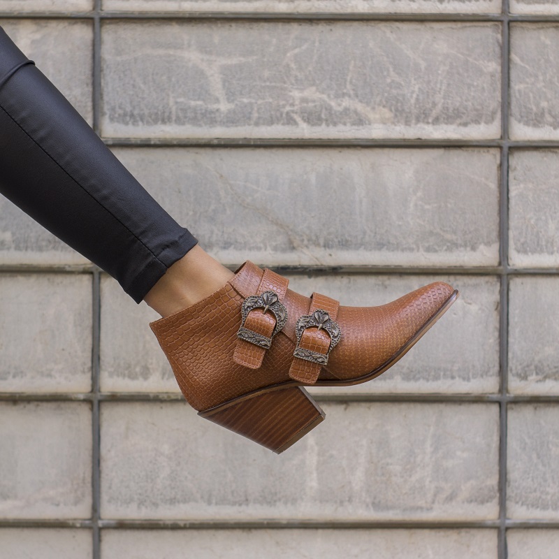 Wedges: Elevation Without Effort A fashionable woman wearing a crocodile patterned brown elegant heel decorated with belts